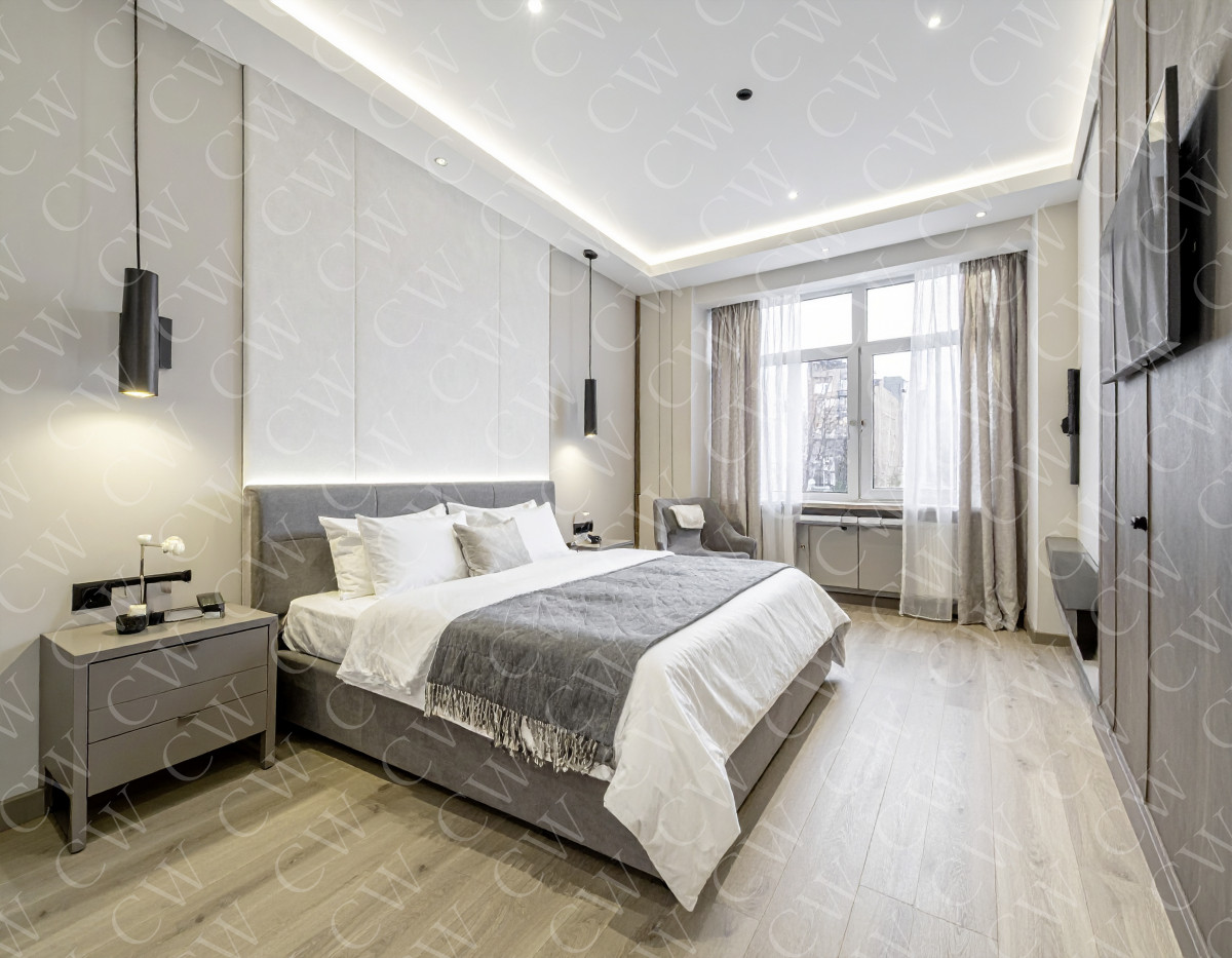 Modern eingerichtetes Schlafzimmer mit Doppelbett, großen Fenstern und hellen Vorhängen.