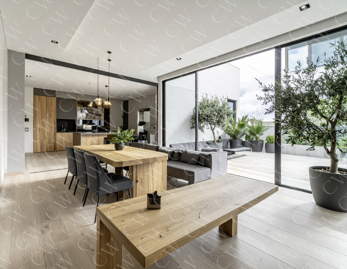 Helles, modernes Wohn- und Esszimmer mit Holztisch und Zugang zur Terrasse