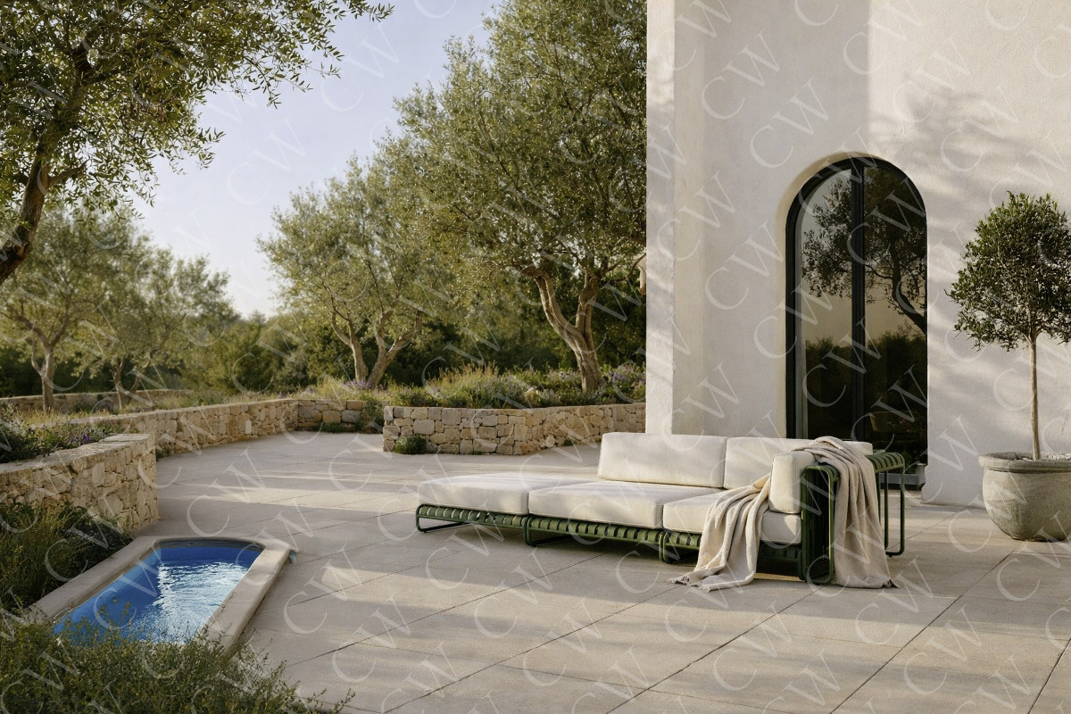 Große Terrasse mit beigem Sofa, Steingarten, Bäumen und kleinem Wasserbecken.