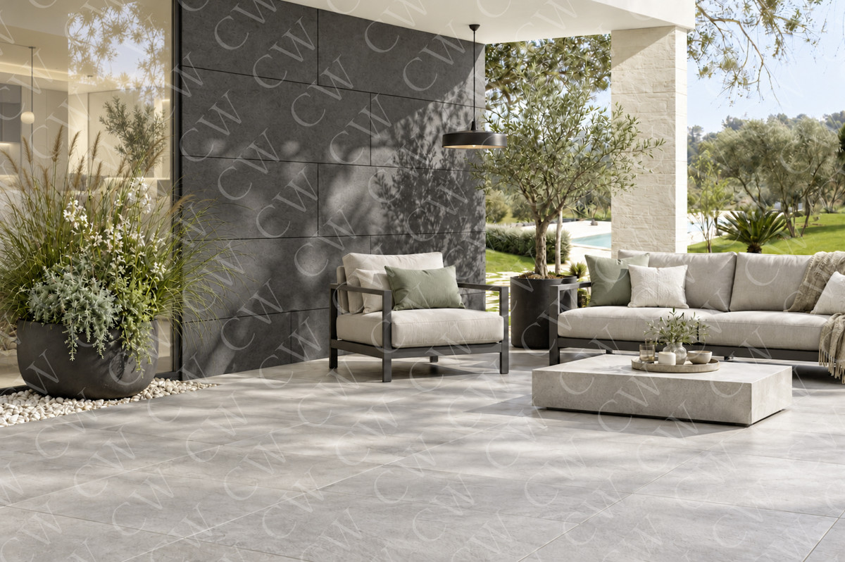 Moderne Terrasse mit grauen Bodenfliesen, bequemen Loungemöbeln und Pflanzen.